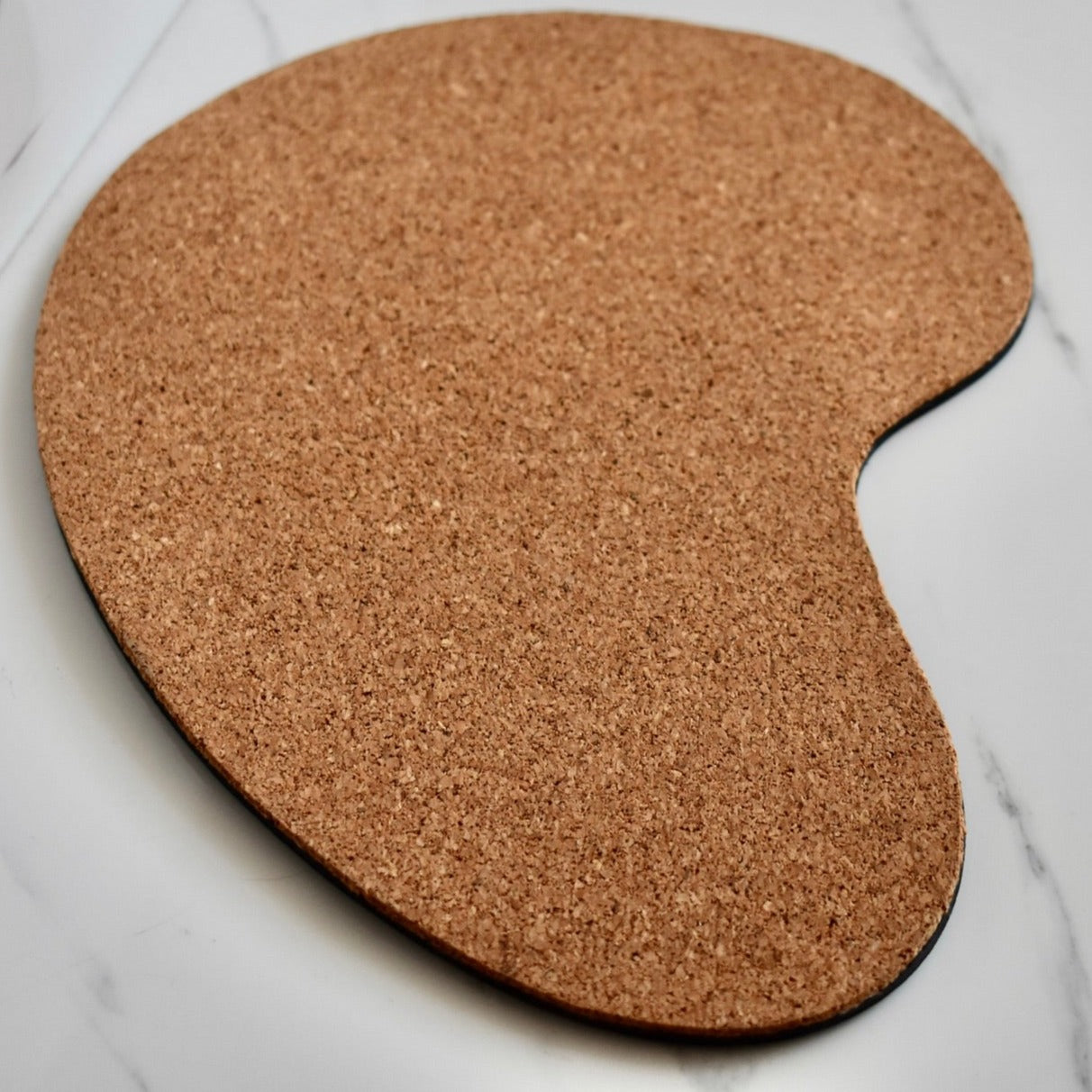 Handmade, organic shaped, genuine leather mouse pad.