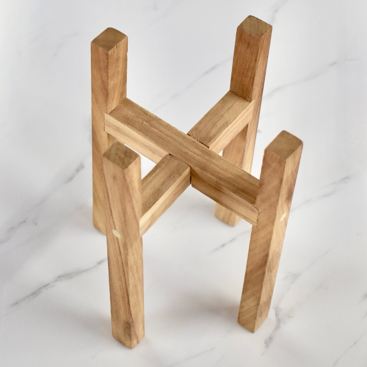 This exquisite wooden plant stand, handcrafted with solid Kiaat wood, is the perfect addition to any plant lover's collection. With its elegant and sophisticated design, it will elevate any space it graces. Stand only.