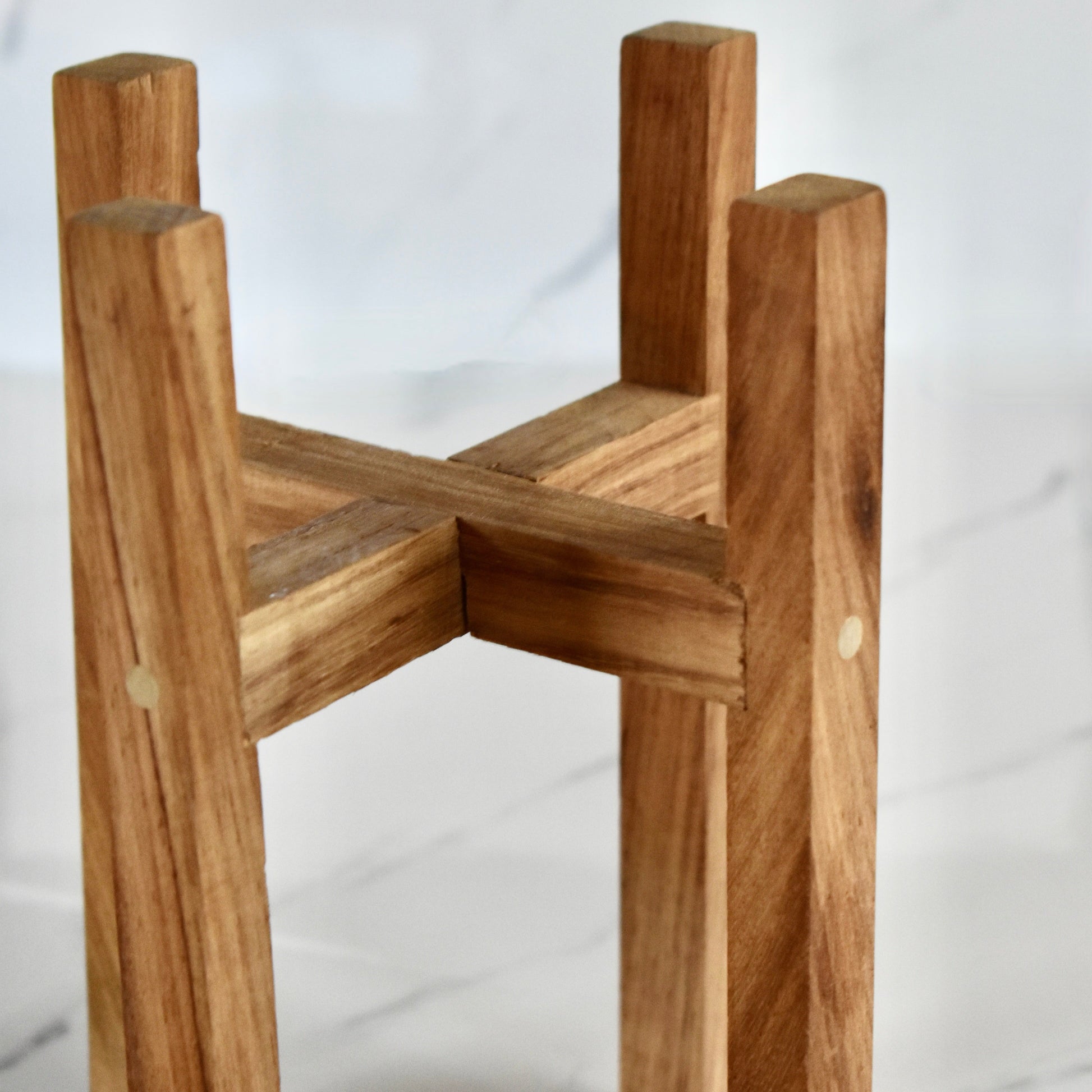 This exquisite wooden plant stand, handcrafted with solid Kiaat wood, is the perfect addition to any plant lover's collection. With its elegant and sophisticated design, it will elevate any space it graces. Stand only.