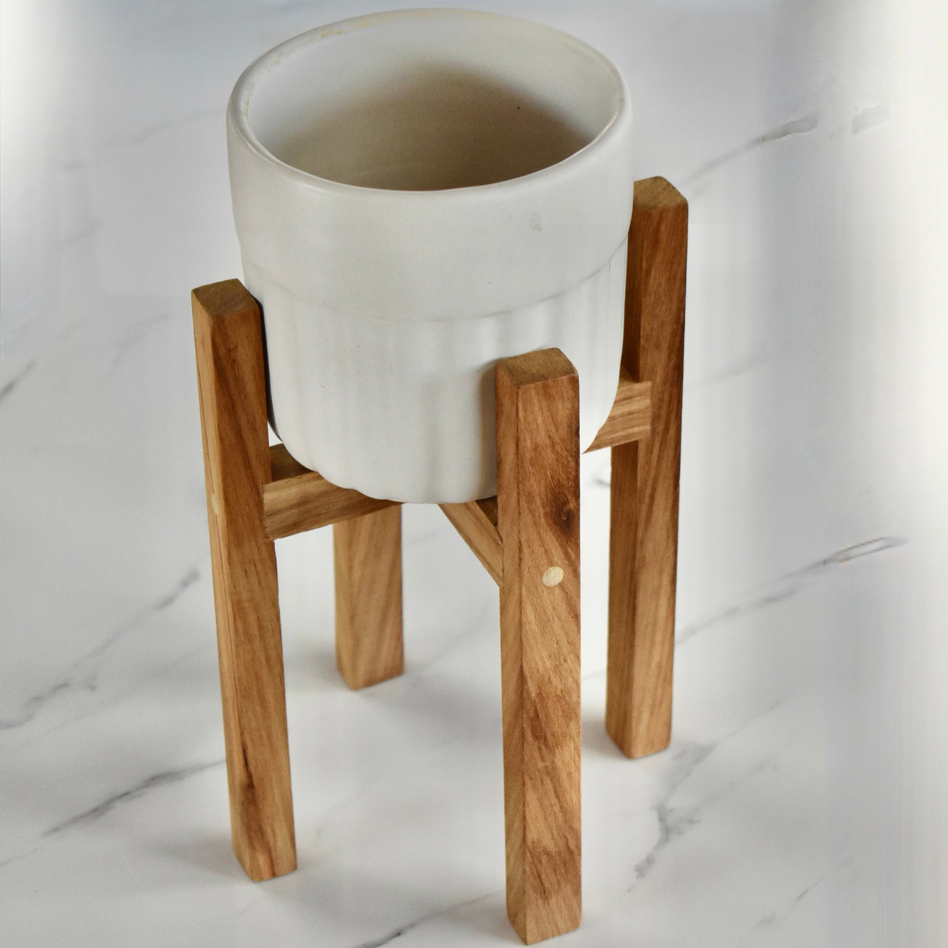 This exquisite wooden plant stand, handcrafted with solid Kiaat wood, is the perfect addition to any plant lover's collection. With its elegant and sophisticated design, it will elevate any space it graces. Stand only.